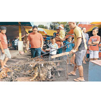 印尼狗肉市集商販把狗隻關在狹小的籠中。（美聯社圖片）