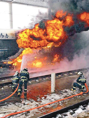 列車噴出火球，消防員在旁射水。（互聯網圖片）