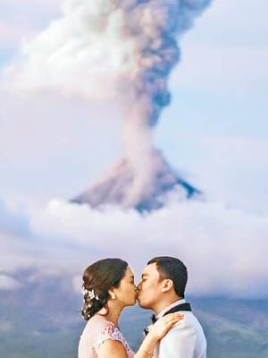 邁卡（左）和魯斯（右）在火山前親吻拍婚照。（互聯網圖片）