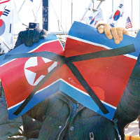 有人於熱身賽場外撕毀北韓國旗。（美聯社圖片）