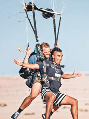 「申俊」（右）日前在微博上載於納米比亞跳傘的照片。（互聯網圖片）