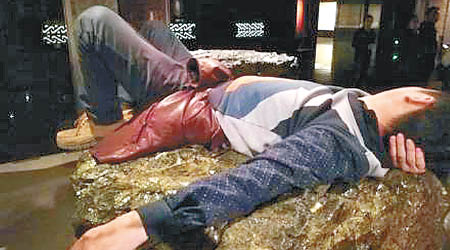 一名男子違規躺在博物館的輔助展品上。（互聯網圖片）