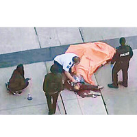 一名死者浴血路邊，遺體被覆蓋。（互聯網圖片）