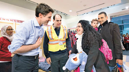杜魯多（左）曾親迎抵加拿大難民。