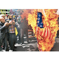 示威者焚燒美國國旗。（美聯社圖片）