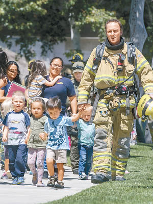 消防員協助疏散學童。（美聯社圖片）