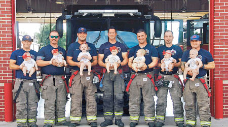 七名消防員抱着自己的孩子合照。（互聯網圖片）