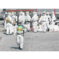 工作人員進入福島第一核電站須穿上保護衣。