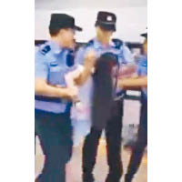 兩名男警將該女子架走。