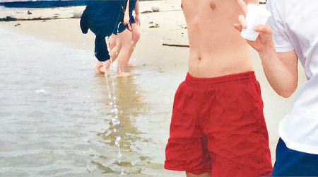 有男生在水中脫去上衣。（互聯網圖片）