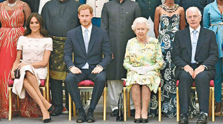梅根（左一）坐下時蹺腳，被指不尊重英女王（右二）。（美聯社圖片）