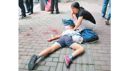 一名女子用毛巾按壓男生頸部傷口止血。（互聯網圖片）