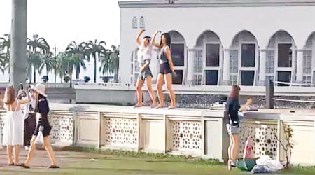 兩名中國女遊客在清真寺圍牆上熱舞。（互聯網圖片）
