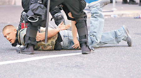警員在衝突中制服一名示威者。（美聯社圖片）