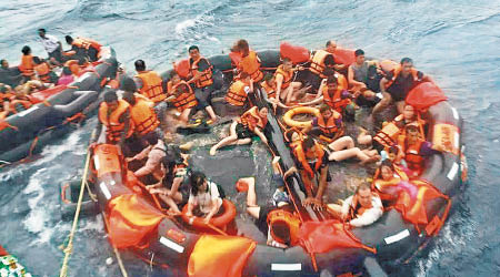 獲救乘客坐在橡皮艇上。