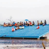 民眾為避洪水，只能逃至屋頂。（互聯網圖片）