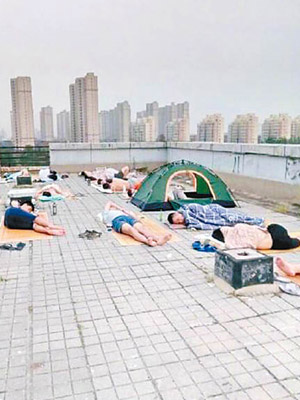 鄭州大學宿舍停電，學生晚上到天台席地而睡。（互聯網圖片）