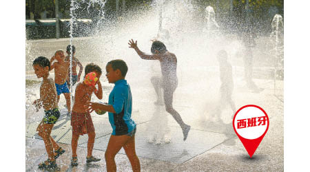 西班牙有小孩在噴泉戲水消暑。（美聯社圖片）