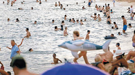 西班牙<br>巴塞隆拿民眾紛紛到海灘戲水。（美聯社圖片）