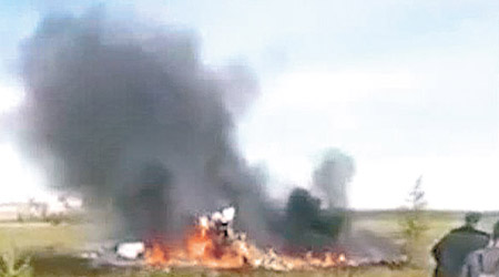 直升機墜毀後着火，冒出濃煙。（美聯社圖片）