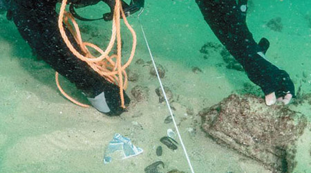 海洋考古學家檢視沉船上的遺物。