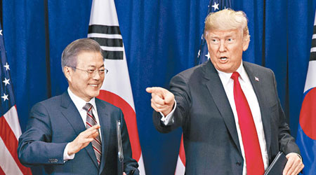 特朗普（右）與文在寅（左）簽署美韓自由貿易協定。（美聯社圖片）