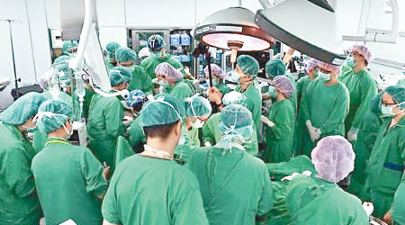 大批醫護人員擁在手術室搶救一對雙胞胎。（互聯網圖片）