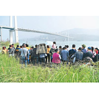 民眾在橋下關注救援進展。（中新社圖片）