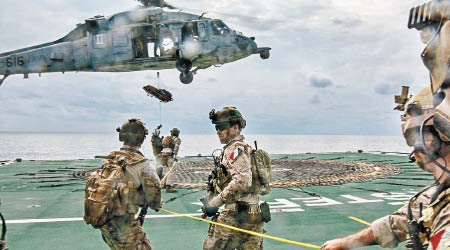 士兵從直升機游繩降落到加拿大的補給艦。