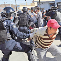 防暴警察阻止難民闖關。（美聯社圖片）