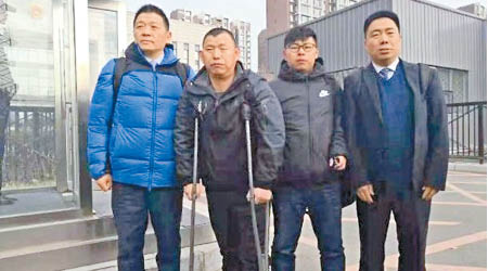 撐着拐杖的金哲宏（左二）在兒子（右二）陪同下離開法庭。（互聯網圖片）