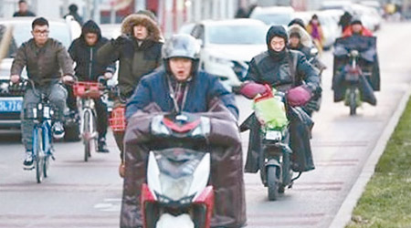 北京<br>天氣嚴寒，民眾穿厚衣，電動車蓋上厚被。（互聯網圖片）