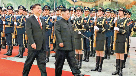 習近平（左）陪同金正恩進入北京人民大會堂。（美聯社圖片）