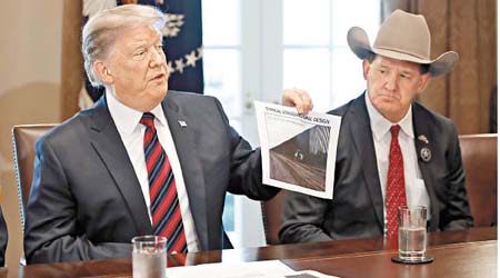 特朗普展示照片，證明有在邊境修築新的圍牆。（美聯社圖片）