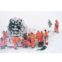 德國<br>工人加緊為火車清理積雪。（美聯社圖片）