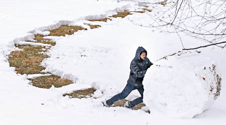 有民眾在滾雪球，作樂一番。（美聯社圖片）