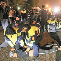 警方將部分激動的民眾壓在地上。