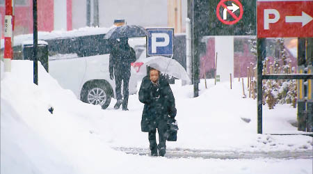 民眾撐傘擋雪。（互聯網圖片）