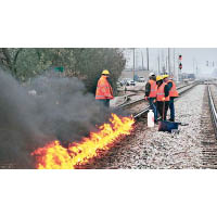 鐵路員工啟動加熱裝置，點火燒路軌以防產生裂痕。