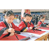 山東<br>學童趁新年在濟南府學文廟用毛筆寫字。（中新社圖片）