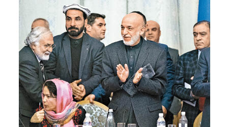 卡扎伊（鼓掌者）與塔利班代表開會。（美聯社圖片）