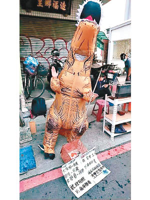 台女學生為籌學費，身穿恐龍裝在街頭賣藝。