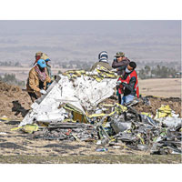 搜救人員在場挖掘客機殘骸。
