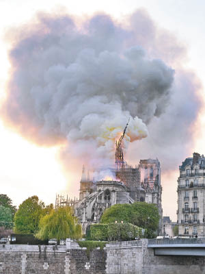 聖母院的尖塔被燒至倒塌，煙霧沖天。（美聯社圖片）