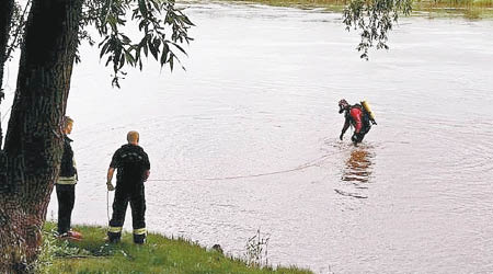警方在河邊打撈遺體。