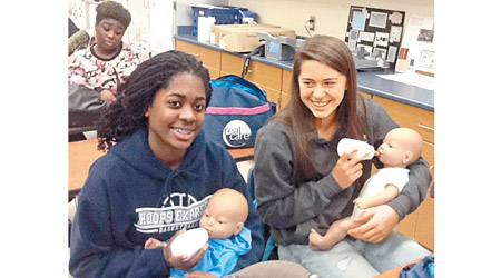 學生抱着嬰兒及餵奶。