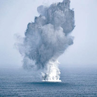 戰機在大海投放炸彈，產生巨大的水花。