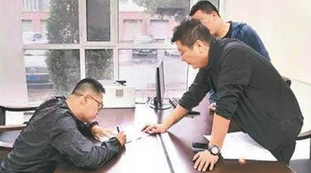 李昊（左）簽署文件。（互聯網圖片）
