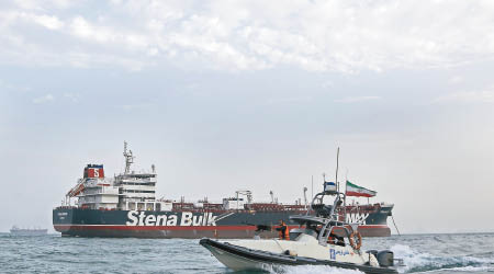 史丹納帝國號（後）被扣押，伊朗革命衞隊快艇（前）在旁巡邏。（美聯社圖片）