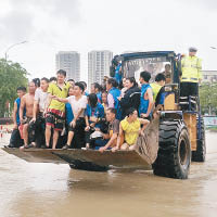 台州<br>受洪水圍困的民眾乘剷車疏散。